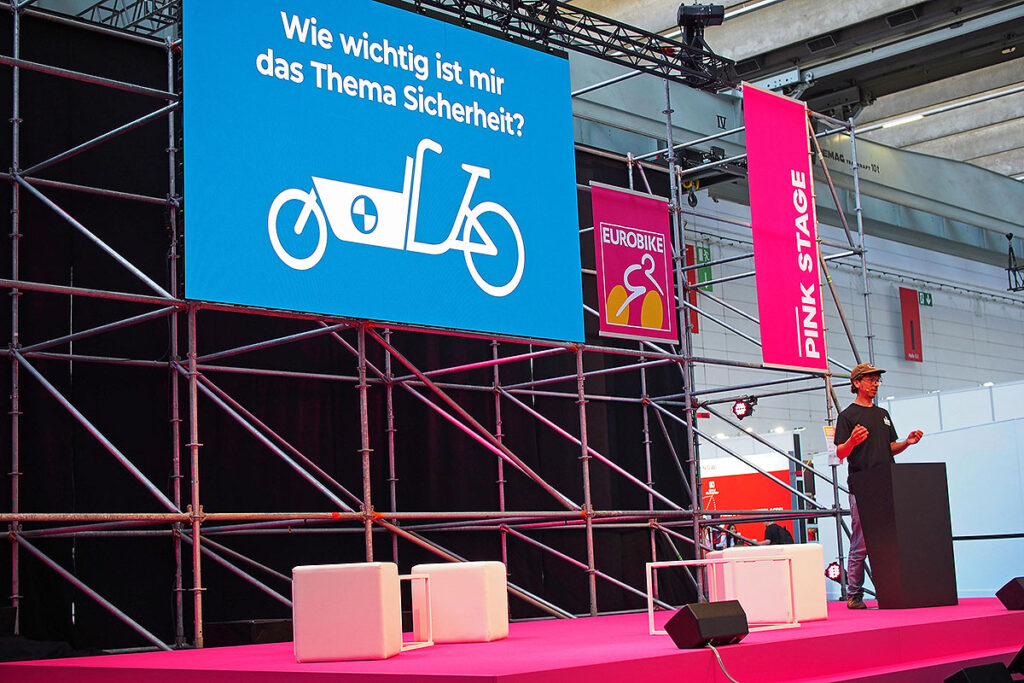 Hinnerk Beetz von cargobike.jetzt auf der Pink Stage zum Thema Lastenräder, Eurobike 2023